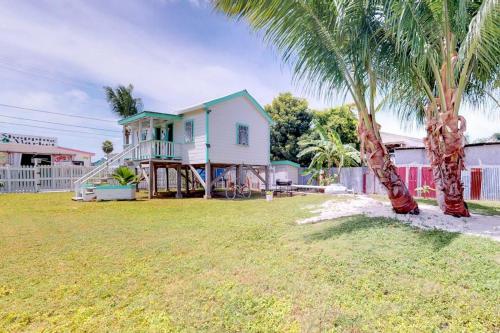 a house with a palm tree in a yard at DV #1 at DV Cabanas - Gold Standard Certified in Caye Caulker