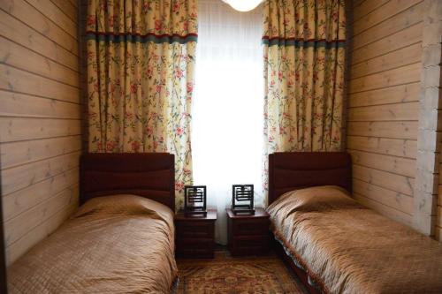two beds in a room with a window at Brech Resort&Spa in Gurinovka Staraya