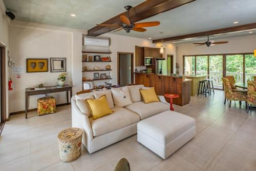 a living room with a white couch and a kitchen at The Reserve in Dangriga
