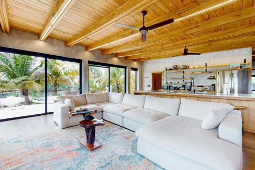 a living room with a white couch and a table at Seabird - Villa 6 in Placencia
