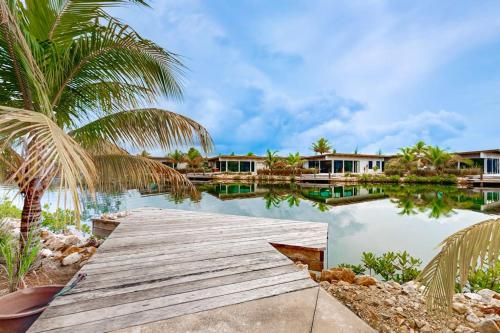 a wooden bridge over a body of water with houses at Seabird - Villa 6 in Placencia