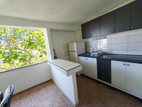 a kitchen with a counter and a window in it at Apartments Šešo C in Pag