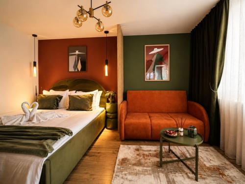 a bedroom with a bed and a couch at Zara Home Cozy Studio in Petroşani