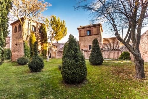 a yard with several trees and a building at Hotel Spa Salinas de Imón in Imón