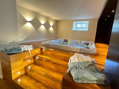 a bathroom with a tub and a wooden floor at Le Domaine Endila in Munster
