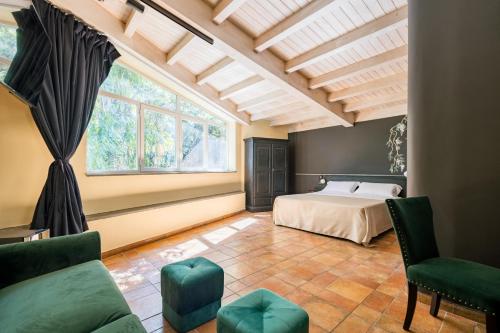 a bedroom with a bed and a large window at Capomulini Boutique Hotel in Capo Mulini
