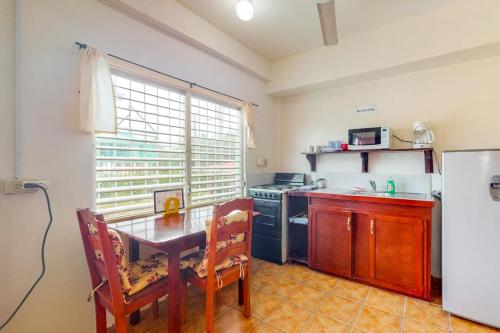 a kitchen with a table and a stove and a refrigerator at Palmetto#1 @ Island Cabanas in Caye Caulker