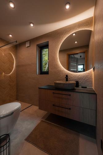 a bathroom with a sink and a mirror at Sploty Lasu u stóp Lubonia - Domki z Jacuzzi in Rabka-Zdrój