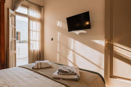 a bedroom with a bed with a television on the wall at Casa Autentica 1933 in Kos