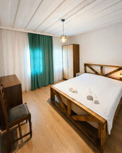 a bedroom with a large bed and a chair at odahouse. fireplace and spring water. in Batumi