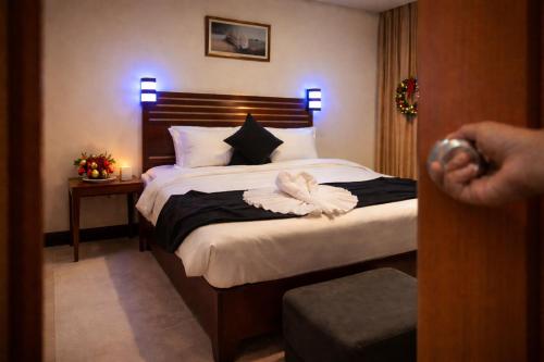 a hotel room with a bed with a person standing in the doorway at The Carlisle Hotel LTD in Asaba