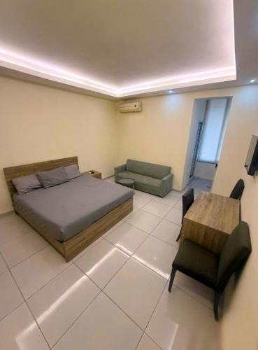 a bedroom with a bed and a table and a chair at Palm Dorms in Beirut