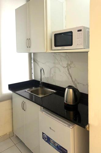 a kitchen with a sink and a microwave at Palm Dorms in Beirut