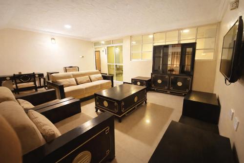 a large living room with a couch and a tv at The Carlisle Hotel LTD in Asaba