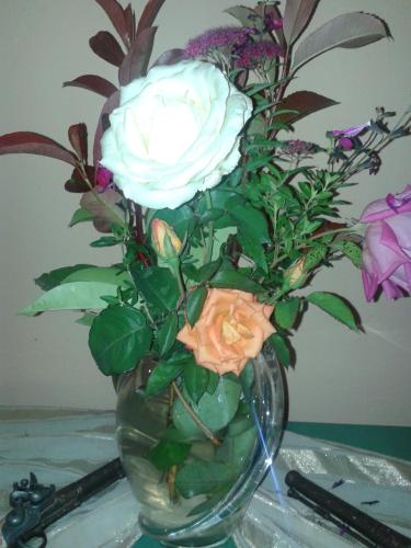 a vase with a white rose sitting on a table at Hotel Dryalos in Miléai
