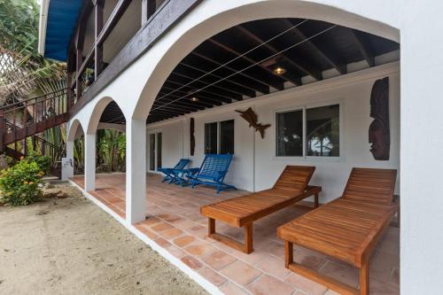 a patio with two benches on a house at Casa Edie in Placencia
