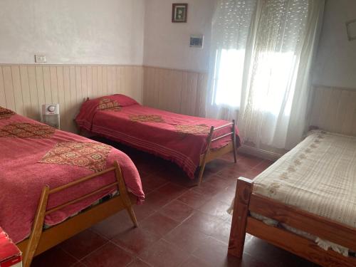 a room with two beds and two chairs in it at La casita in Pringles