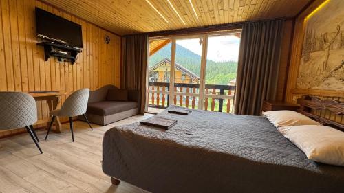 a bedroom with a large bed and a balcony at Demyaniv House in Tatariv