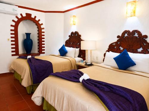 a hotel room with two beds and a mirror at Ecotel Quinta Regia in Valladolid