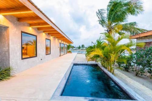 a house with a swimming pool next to a house at Seabird - Villa 10 in Placencia