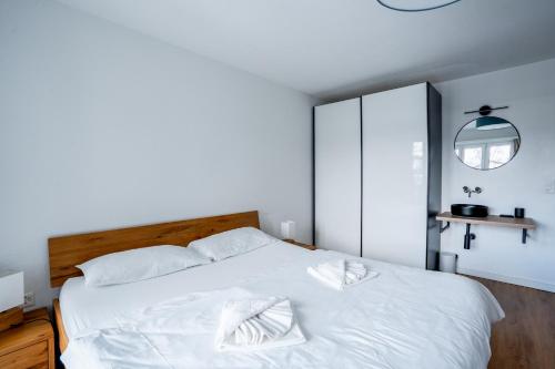 a bedroom with a white bed with two pillows on it at La Riva mit Berg- und Seeblick in Laax