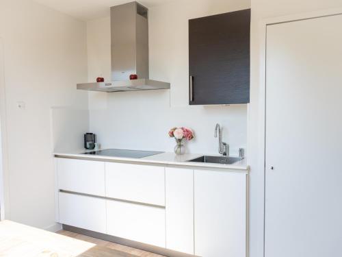 a white kitchen with white cabinets and a sink at Hoeve Tramzicht in Hellevoetsluis