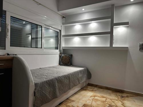 a small bedroom with a bed and a window at Bazakos Luxury Kampi Beach Studio 2 in Fournoi