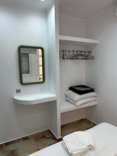 a bathroom with a mirror and towels on a shelf at Bazakos Luxury Kampi Beach Studio 2 in Fournoi