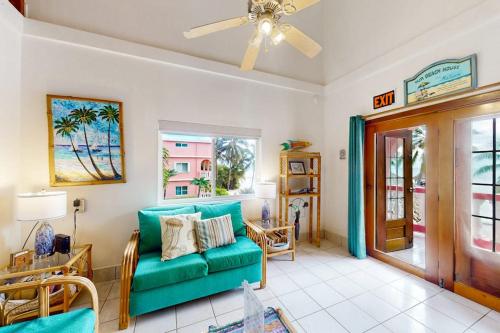 a living room with a green couch and a window at Palm @ Caribe Island in San Pedro