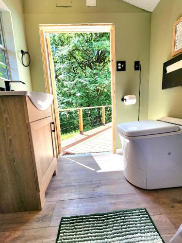 a bathroom with a toilet and an open door at Evergreen Escape in Brush Prairie