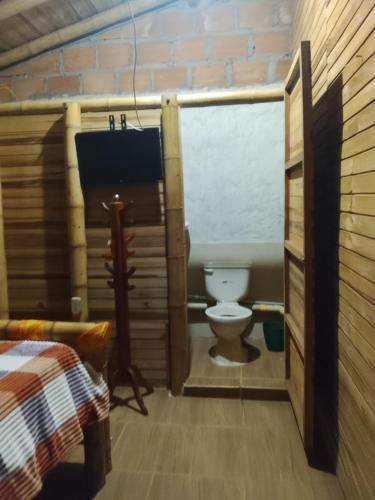 a bathroom with a toilet in a log cabin at Hospedaje Los Tumbilos in Silos