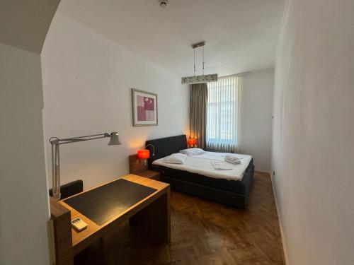 a small room with a bed and a table at Ralf Residence in Bucharest