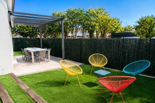 four chairs and a table in a yard at Villa T4 Cosy entre Mer, Montagne & Espagne avec Jardin, Billard & Barbecue in Thuir