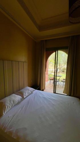 a large bed in a bedroom with a large window at Les Jardins de la Palmeraie 3 in Marrakesh