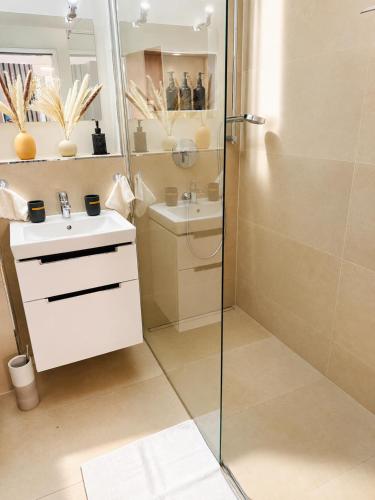 a bathroom with a shower and a sink at Velmora Boutique Suites - Wellness - Pool, Sauna, E-Bikes direkt am Strand in Timmendorfer Strand