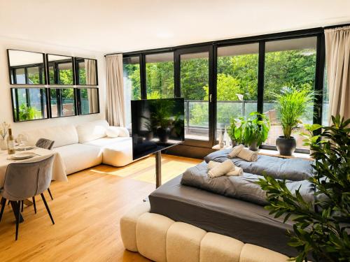 a living room with a couch and a large window at Velmora Boutique Suites - Wellness - Pool, Sauna, E-Bikes direkt am Strand in Timmendorfer Strand