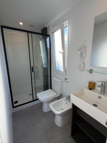 a white bathroom with a toilet and a sink at Camping Matija in Betina