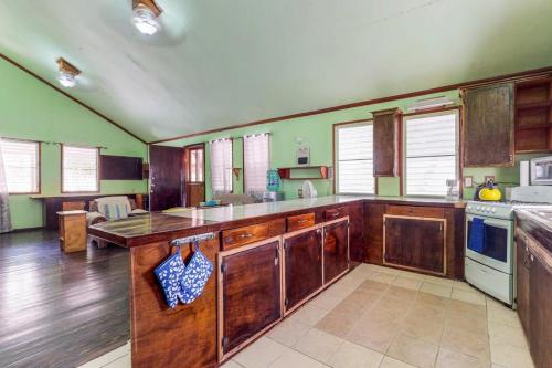 a large kitchen with wooden cabinets and green walls at Casa Jessita in Caye Caulker