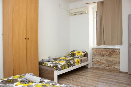 ein Schlafzimmer mit zwei Betten und einem Fenster in der Unterkunft Hostel Centuria in Pula