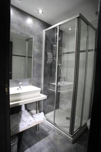 a bathroom with a glass shower and a sink at Douris Temple in Soria