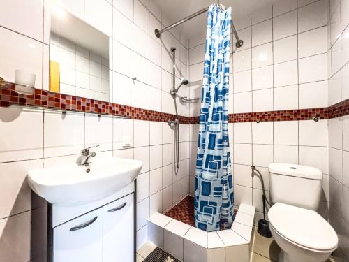 a bathroom with a toilet sink and a shower curtain at Pensjonat Viki in Sarbinowo