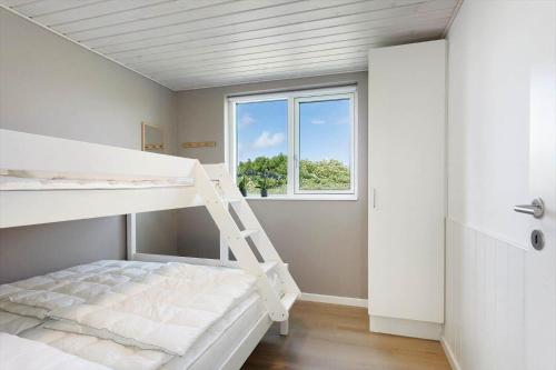 a bedroom with a bunk bed and a window at TV1737-Bindslev-Mellemklitvej-23 in Tversted