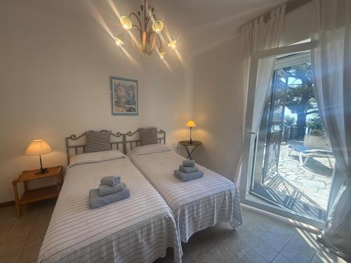 a bedroom with two beds and a large window at Villa Fronte Mare Con Terrazza in Marina di Andora