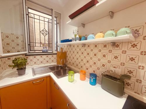 a kitchen with yellow cabinets and a sink and a window at Villa Fronte Mare Con Terrazza in Marina di Andora