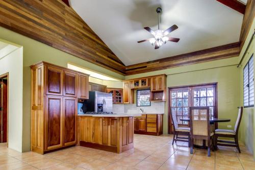 a kitchen with wooden cabinets and a ceiling fan at Suite at Villa Maya -Gold Standard and Certified in San Ignacio