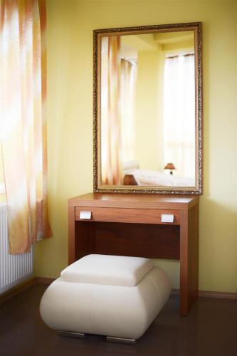a bathroom with a mirror and a stool under a sink at Hotel Copernicus in Lubawa