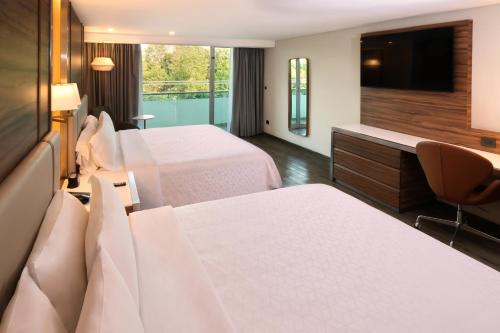 a hotel room with two beds and a television at Holiday Inn Mexico Zona Centro by IHG in Mexico City