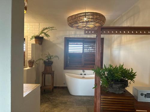 a bathroom with a tub and a sink with potted plants at Casa da dunas in Prea