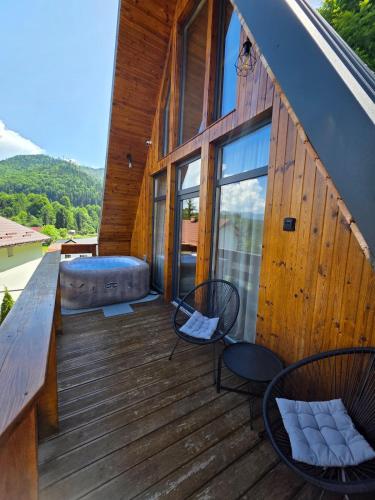 a deck with chairs and a bench on a house at Cabana BBO - Jacuzzi, TV and Terasse in Colibiţa
