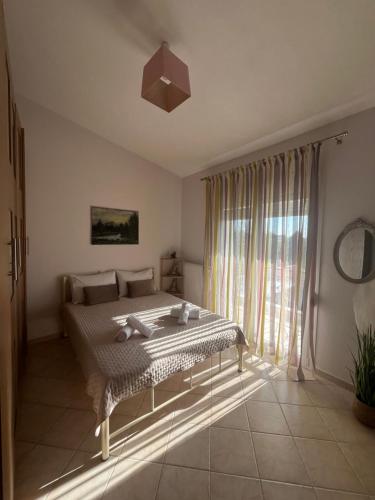 a bedroom with a bed and a large window at Eri's House in Chrysoupolis